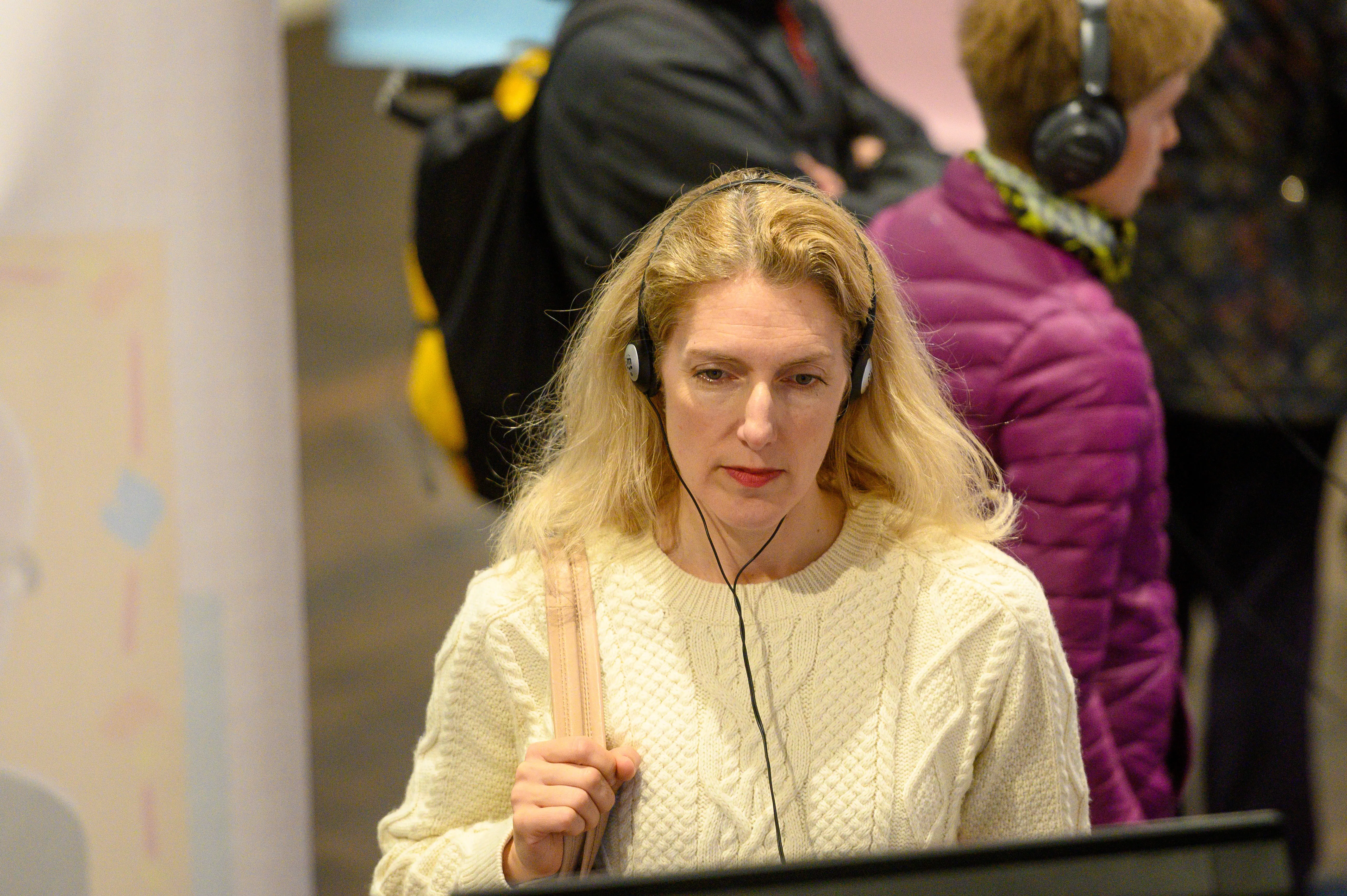 Woman at exhibition using an audioguide.