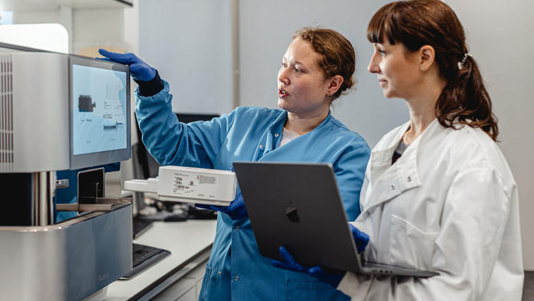 Two women scientists looking at lab equipment