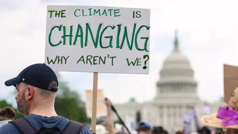 Protester holding up sign about climate change